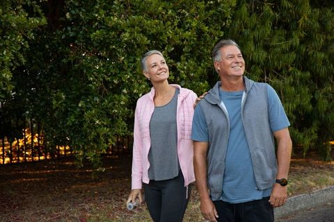 Senior Couple Enjoying Leisure Nature Walk on Sidewalk
