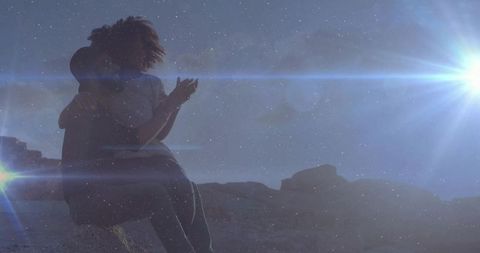 Couple Embracing in Desert with Sun Flares and Starry Sky Vibe