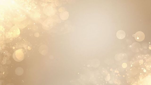 Golden bokeh glow backdrop with soft glitter, luminous highlights and subtle lens flares