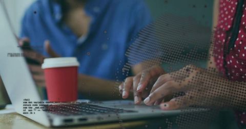 Hands typing on laptop with coffee cup, coding and collaborating with digital map overlay