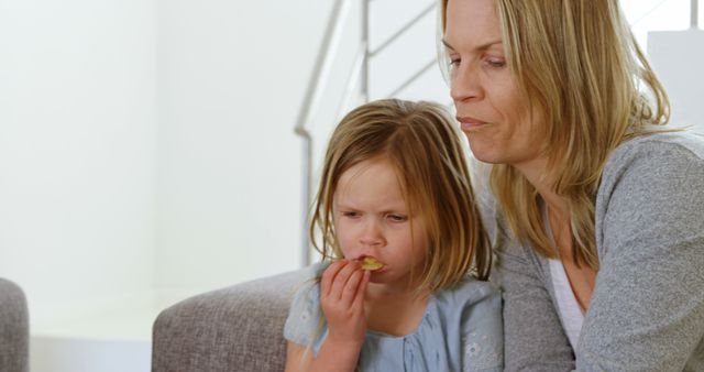 Mother and Daughter Relaxing on Couch Eating Snacks - Download Free Stock Images Pikwizard.com