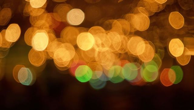 Golden hexagonal bokeh lights shimmering over nightscape with multicolor out-of-focus orbs