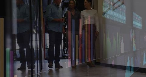 Business team walking through modern office corridor with glass data visualizations