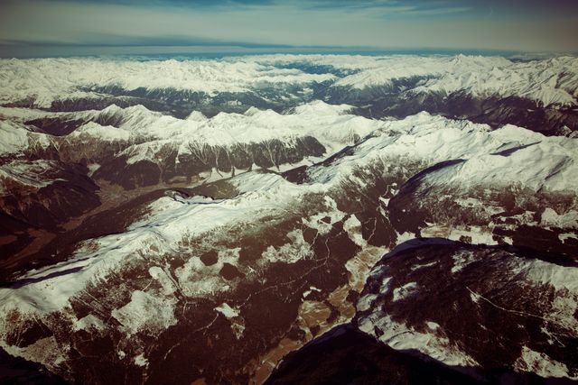 Aerial View of Snow-Covered Rocky Mountains with Clear Sky - Download Free Stock Photos Pikwizard.com