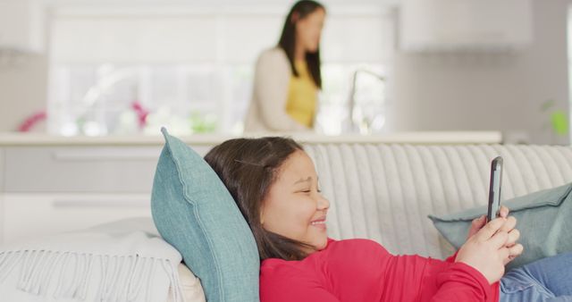 Happy Girl Using Smartphone While Relaxing on Couch at Home - Download Free Stock Images Pikwizard.com