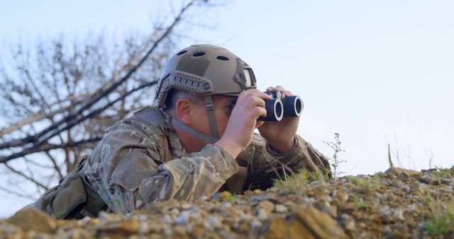 Soldier In Full Gear Observing With Binoculars In Camouflaged Position - Download Free Stock Images Pikwizard.com