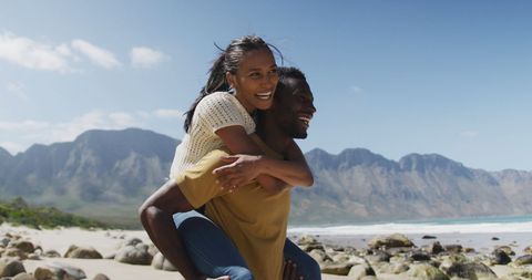 Joyful Couple Embracing Fun Beach Adventure by Mountain - Download Free Stock Images Pikwizard.com