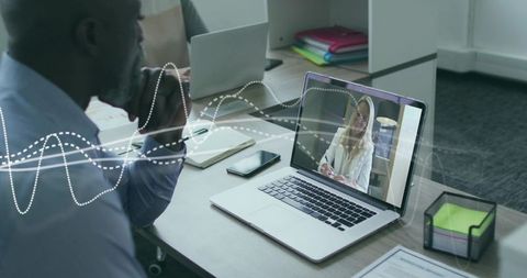 Businessman at Desk in Virtual Meeting with Digital Interface
