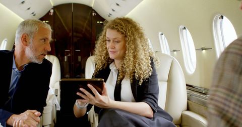 Business partners reviewing strategy on private jet