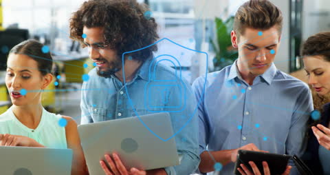 Coworkers engage in discussions about technology and digital safety, demonstrating teamwork in an office setting. Ideal for illustrating concepts of cybersecurity, data protection, and collaborative work environments in tech industries.