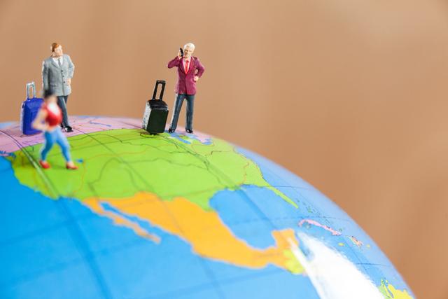 Conceptual image of miniature people travelling on globe