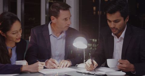 Diverse Team Analyzing Financial Data in Office at Night