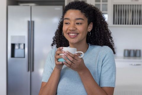 Smiling Woman Enjoying Coffee in Modern Kitchen