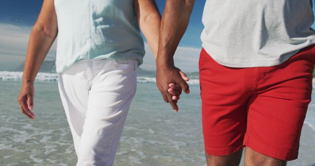 Couple walking along beach holding hands. Ideal for marketing content in the travel and tourism industry, advertising romantic beach vacations, relationship and lifestyle blogs, or health and well-being websites.