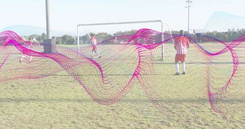Youth soccer players defending goal during practice with magenta-cyan data wave overlay