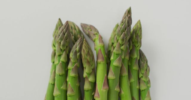 Image of close up of fresh asparagus over white background. fusion food, fresh vegetables and healthy eating concept.