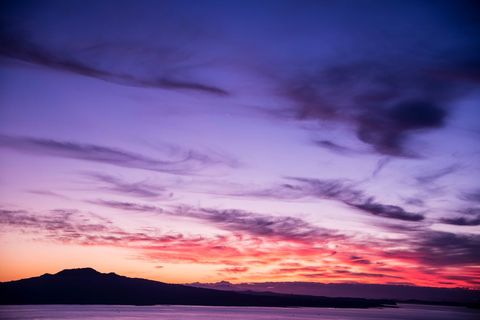 Violet Sky Painting Pink and Orange Horizon, Mountain Silhouette Reflecting on Calm Water