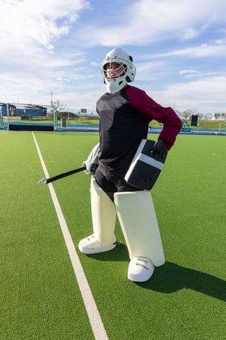 Field Hockey Goalkeeper Equipped and Standing Guarding Turf Goal