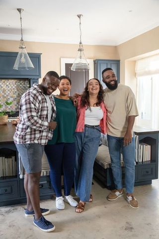 Diverse friends embracing in modern kitchen setting