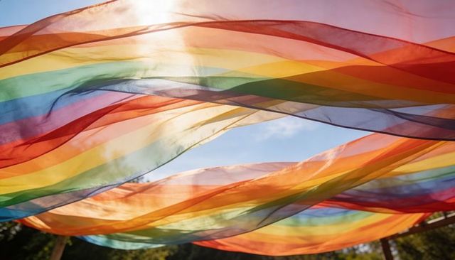 Translucent rainbow canopy rippling over park with sunlight filtering through layers