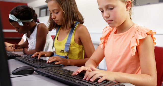 Children practicing typing skills in a school computer lab, showcasing digital literacy education. This can be used for educational materials, articles on digital literacy, school technology programs, or advertisements for educational software.