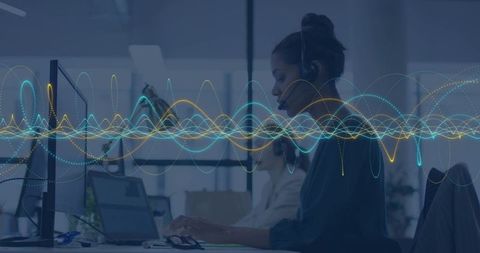 Customer service agent typing with headset and voice waveform overlay in modern office