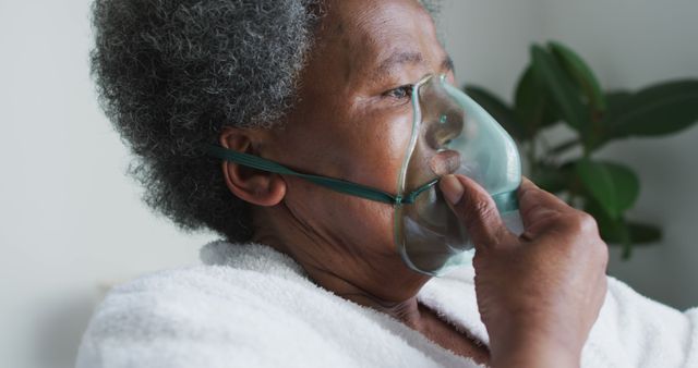 African american senior woman breathing using an oxygen mask at home. senior healthcare, support and lifestyle.