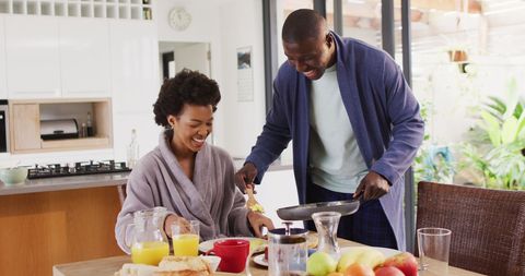 Smiling Couple Enjoying Breakfast Together in Modern Kitchen