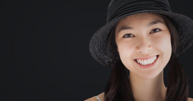 Smiling Woman Wearing Black Hat Against Dark Grey Background - Download Free Stock Photos Pikwizard.com