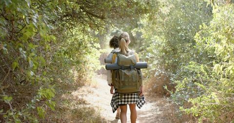 Young woman hiking through lush forest adventure