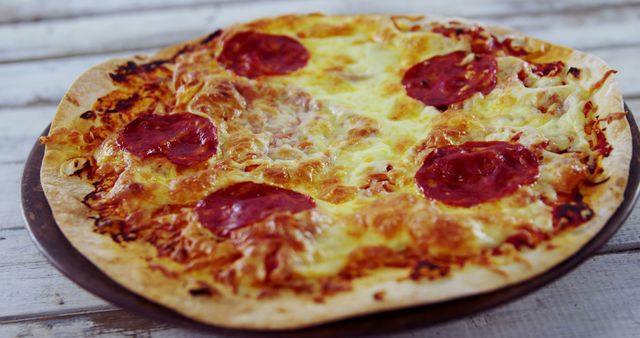 Freshly baked pepperoni pizza with melting cheese on a rustic table. Perfect for food blogs, restaurant menus, and cookbook illustrations.