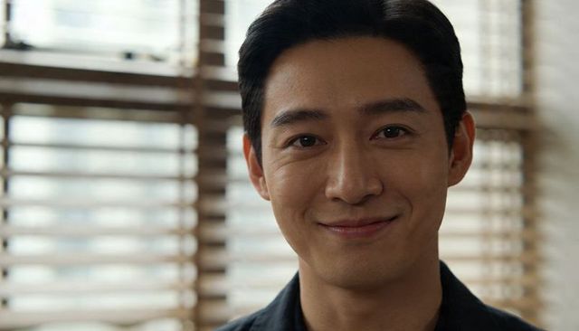 Warm smiling asian businessman headshot with wooden blinds background and natural daylight