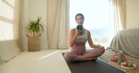 Woman Practicing Yoga in Sunlit Minimalist Bedroom
