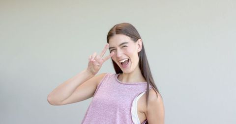 Joyful Teenage Girl Flashing Peace Sign