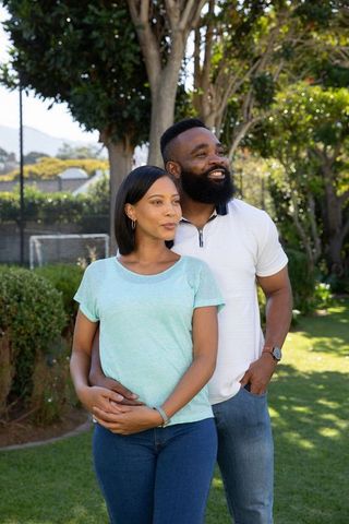 Diverse Couple Enjoying Peaceful Moment in Lush Backyard Garden