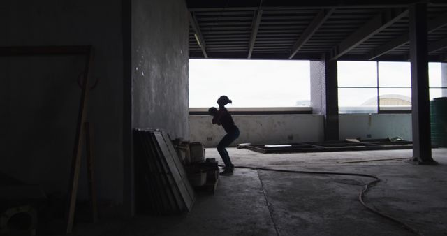 Silhouetted Worker Engaging in Construction Work Inside Building - Download Free Stock Images Pikwizard.com