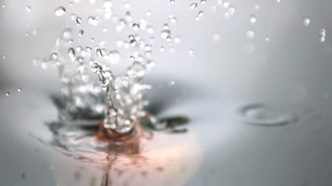 Red Apple Making Splash in Water Droplets in Slow Motion