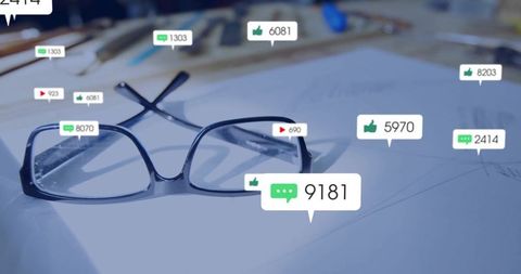 Eyeglasses on sketch-filled designer desk with virtual engagement alerts