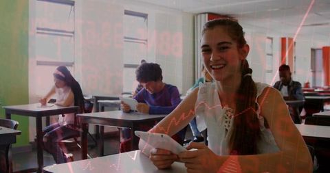 Smiling teen girl using tablet in classroom with red data overlay, digital learning scene