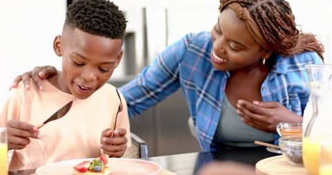 Mother Bonding with Son During Breakfast at Home
