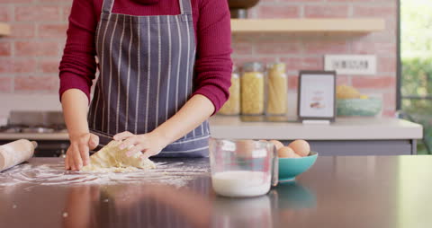 Person Kneading Dough on Countertop in Cozy Kitchen