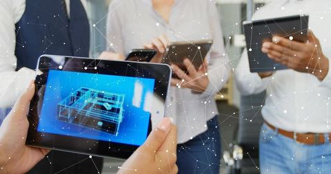 Professionals Analyzing 3D Model on Tablets in Collaborative Environment