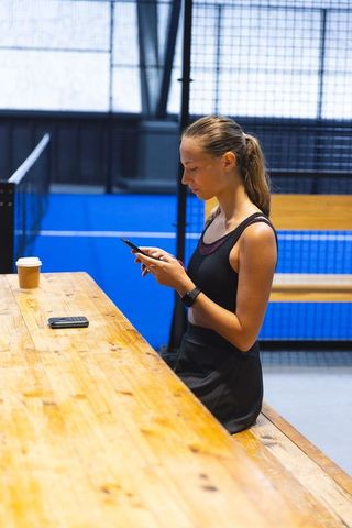 Fit Athlete in Sportswear Checking Phone at Indoor Court