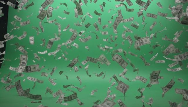 Floating us dollar bills over chroma-key green backdrop creating dramatic money rain