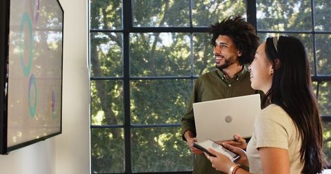 Diverse Colleagues Discussing Presentation in Modern Office