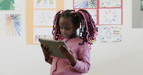African american girl using tablet for learning in classroom