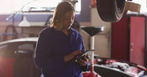 Biracial Female Mechanic Using Tablet in Car Repair Garage - Download Free Stock Images Pikwizard.com