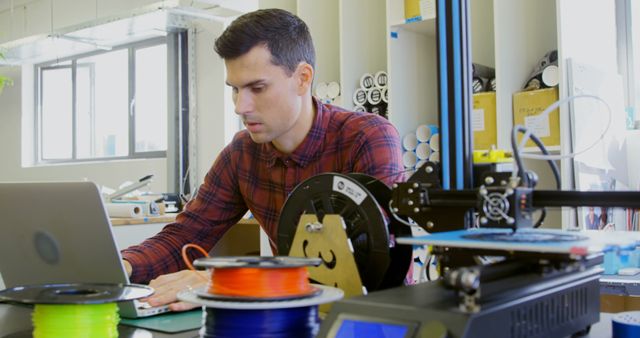 Focused Engineer Working on Laptop in Modern Workshop with 3D Printer - Download Free Stock Images Pikwizard.com