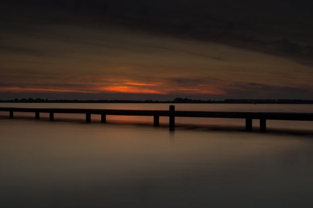 Serene Sunset Over Calm Body of Water - Download Free Stock Images Pikwizard.com