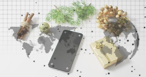 Showing black smartphone with screws, gold gift box and festive ornaments on grid halftone world map